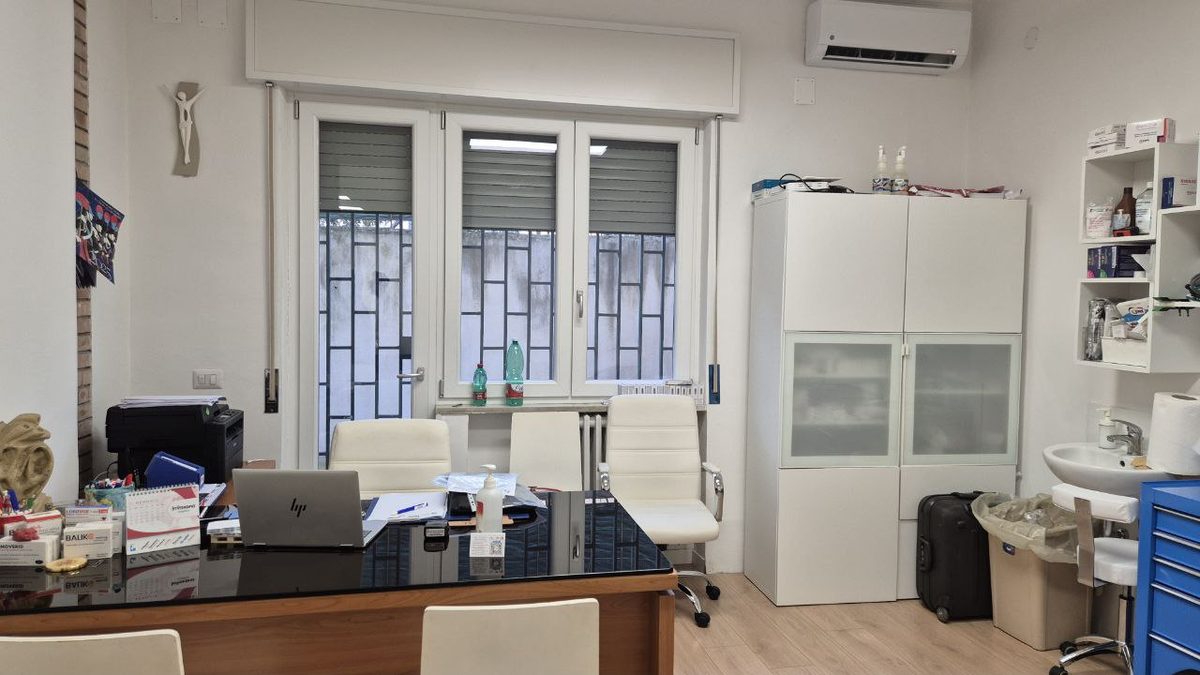 Studio di Scafati, Via Brindisi 12: scrivania per le visite davanti a una finestra luminosa, con armadio e lavandino.